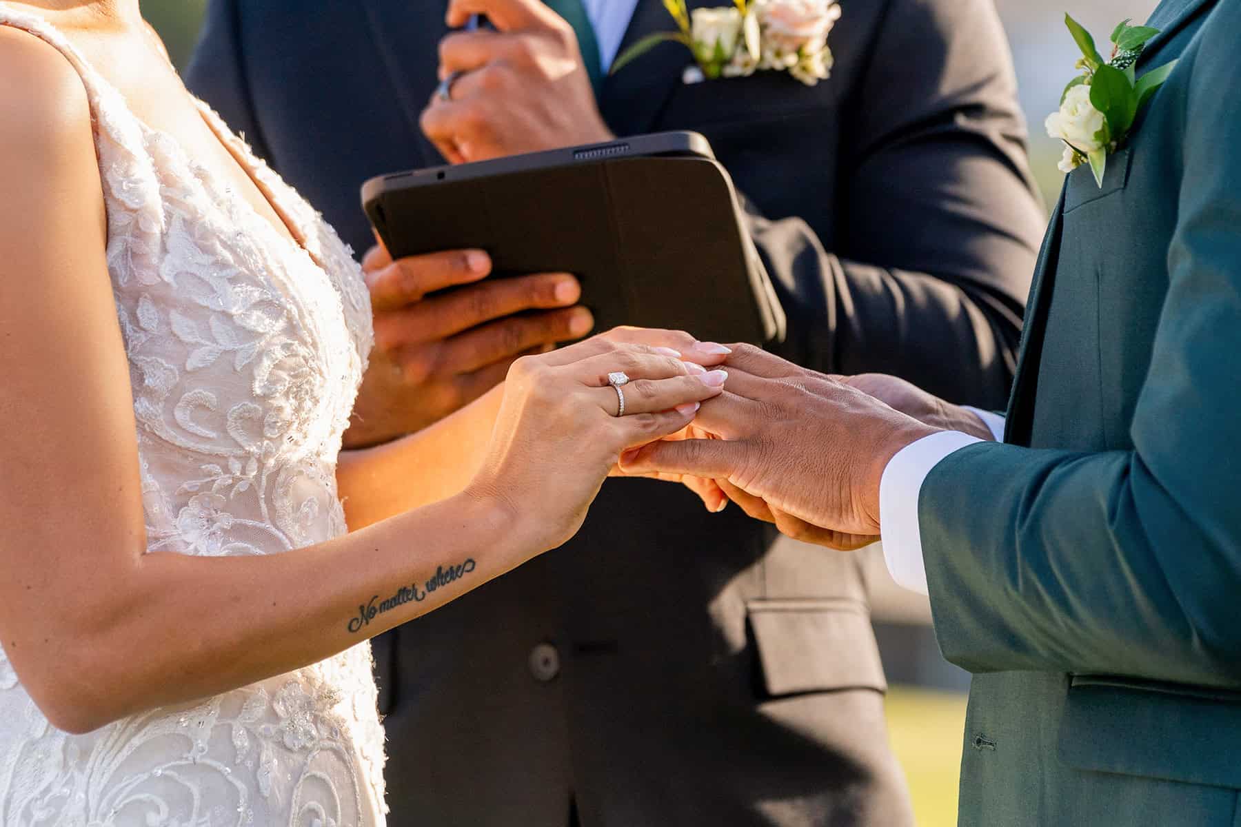 close-up-ring-exchange-san-diego-wedding Close-up of bride and groom exchanging wedding rings during outdoor ceremony in San Diego