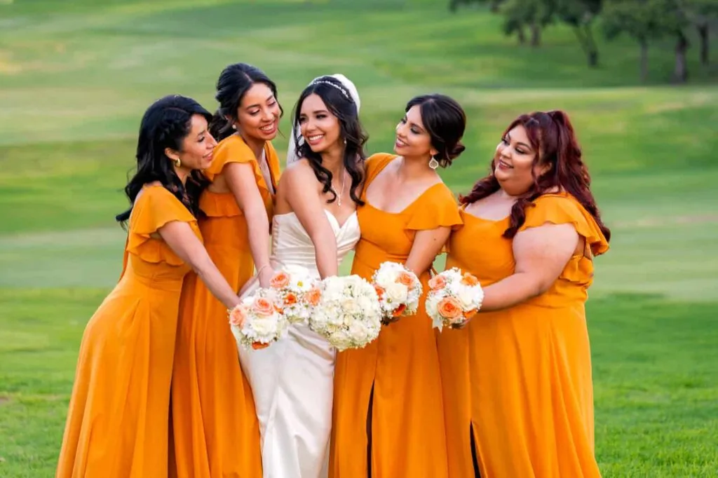 San Diego bride with bridesmaids in mustard dresses holding bouquets at a golf course wedding venue