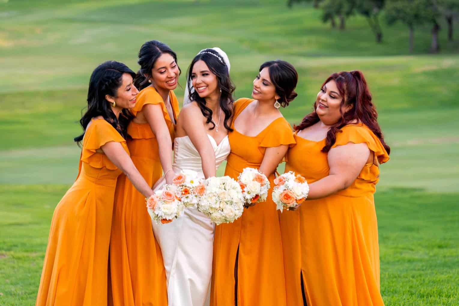 san-diego-wedding-photographer-bride-bridesmaids-golf-course San Diego bride with bridesmaids in mustard dresses holding bouquets at a golf course wedding venue