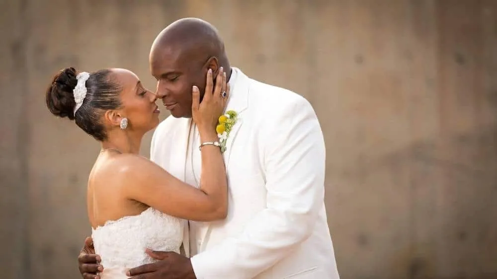 Bride and groom in white attire embracing and smiling during San Diego wedding portrait session